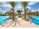 Stunning community pool area with palm trees, thatched umbrellas, lounge chairs and inviting shallow water entry at 311 Pop Top Ln, Daytona Beach, FL 32124
