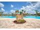 Charming community pool area with a sign post and bridge connecting pool areas, surrounded by tropical landscaping at 311 Pop Top Ln, Daytona Beach, FL 32124