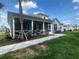 Charming light blue single-Gathering home with a screened-in porch and well-maintained landscaping at 311 Pop Top Ln, Daytona Beach, FL 32124