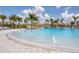 Beautiful community pool with splash fountains, thatched umbrellas, palm trees, and comfortable lounge seating areas at 311 Pop Top Ln, Daytona Beach, FL 32124