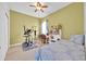 Well-lit bedroom with tile flooring, ceiling fan, and an exercise machine at 675 Elbridge Dr, Kissimmee, FL 34758