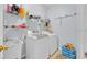 A functional laundry room with modern appliances, storage shelves, and ample space for efficient chores at 675 Elbridge Dr, Kissimmee, FL 34758