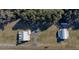 Aerial view of two homes with metal roofs, situated on expansive green lawns with mature trees and a circular driveway at 2198 W Highway 329, Citra, FL 32113