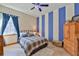 Bedroom with blue-and-white striped wall, wood floors, and wood furnishings at 2198 W Highway 329, Citra, FL 32113