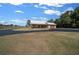 Scenic view of a home with a metal roof, set back from a circular driveway and surrounded by mature trees at 2198 W Highway 329, Citra, FL 32113