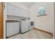 Well-lit laundry room with white cabinets, countertops, a utility sink, and a washer and dryer at 2198 W Highway 329, Citra, FL 32113