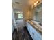 Bathroom featuring dual sinks, granite countertops, modern fixtures, and an adjoining bedroom at 6711 Sw 64Th Ave, Ocala, FL 34476