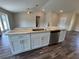 Kitchen island with stainless steel dishwasher and sink, marble countertops, and white cabinets at 6711 Sw 64Th Ave, Ocala, FL 34476