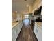 Modern kitchen featuring stainless steel appliances, white cabinets and dark wood floors at 6711 Sw 64Th Ave, Ocala, FL 34476