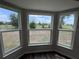Bright room featuring three large windows offering scenic outdoor views and natural light at 6711 Sw 64Th Ave, Ocala, FL 34476