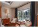 Comfortable bedroom nook with window view, featuring stylish chairs, dark drapes, and natural lighting at 10411 Sw 52Nd Ct, Ocala, FL 34476