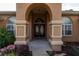 Elegant entryway with arched doorway and double doors, complemented by lush landscaping at 10411 Sw 52Nd Ct, Ocala, FL 34476