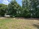 View of the backyard of the property with shade trees and grass at 7051 Sw 64Th Ter, Ocala, FL 34476