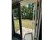 View of backyard through French doors to a grassy area with trees at 7051 Sw 64Th Ter, Ocala, FL 34476