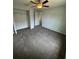 Comfortable carpeted bedroom featuring a ceiling fan and ample closet space, perfect for relaxation at 7051 Sw 64Th Ter, Ocala, FL 34476