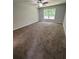 Carpeted bedroom featuring a ceiling fan and large window, offering a comfortable and inviting space at 7051 Sw 64Th Ter, Ocala, FL 34476