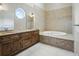 Bathroom featuring a jacuzzi tub with granite surround, double vanity and a patterned wall at 10621 Sw 11Th Ter, Ocala, FL 34476
