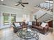 Spacious living room featuring a comfortable sofa, and view of the staircase and outdoor living at 10621 Sw 11Th Ter, Ocala, FL 34476