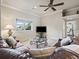 Comfortable living room with large couch, ceiling fan and a window with views of the surrounding landscape at 10621 Sw 11Th Ter, Ocala, FL 34476