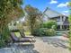 Outdoor patio with two lounge chairs, lush greenery, and a pool in the background at 10621 Sw 11Th Ter, Ocala, FL 34476