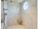Shower with pebble design and seat with rain shower head and octagon window at 10621 Sw 11Th Ter, Ocala, FL 34476