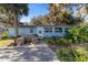 Light blue house exterior with stone fire pit and landscaping at 22345 Ne 108Th Avenue Rd, Fort Mc Coy, FL 32134