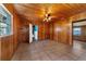 Living room with wood paneled walls, tiled floors, and ceiling fan at 22345 Ne 108Th Avenue Rd, Fort Mc Coy, FL 32134