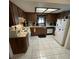 Traditional kitchen with wood cabinets, white appliances and countertops, window over the sink, and tile flooring at 10300 Sw 98Th Ter, Ocala, FL 34481