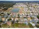 An aerial view of a community with a pond, showcasing well-maintained homes and landscaping at 8447 Se 137Th Loop, Summerfield, FL 34491
