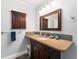 Cozy bathroom with wood-toned vanity, mirror, and storage cabinet, offering a warm and inviting space at 8447 Se 137Th Loop, Summerfield, FL 34491
