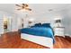 Spacious main bedroom with wood floors, ceiling fan, and ensuite bath access at 8447 Se 137Th Loop, Summerfield, FL 34491