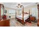 Main bedroom with a four poster bed, tray ceiling, and bright natural light at 8160 Sw 92Nd Cir, Ocala, FL 34481