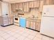 Kitchen with wood cabinets, white appliances, and light tile floor at 19728 Sw 83Rd Place Rd # A-1, Dunnellon, FL 34432