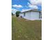 An outdoor view of the air conditioner sitting outside of this beautiful white home with blue skies at 9951 Sw 62Nd Ter, Ocala, FL 34476