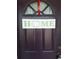 A welcoming front door adorned with a decorative HOME sign and a red ribbon for a touch of charm at 9951 Sw 62Nd Ter, Ocala, FL 34476