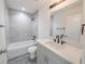 Well-lit bathroom featuring a shower-tub combination, a sleek vanity, and modern fixtures at 13026 Ne 6 Pl, Silver Springs, FL 34488