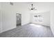 Bright bedroom with gray wood-look floors, ceiling fan, and attached bathroom for a modern and comfortable living space at 13026 Ne 6 Pl, Silver Springs, FL 34488