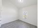 Clean, bright bedroom with gray wood-look floors and a window providing natural light at 13026 Ne 6 Pl, Silver Springs, FL 34488