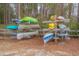 Outdoor canoe storage rack with multiple colorful canoes and kayaks in a wooded community at 13026 Ne 6 Pl, Silver Springs, FL 34488