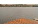 View from a wooden dock, facing a tranquil lake surrounded by trees at 13026 Ne 6 Pl, Silver Springs, FL 34488