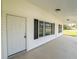 Inviting covered front porch with white siding, black shutters, and concrete flooring at 13026 Ne 6 Pl, Silver Springs, FL 34488