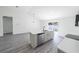 Modern kitchen island with stainless appliances and gray wood-style floors at 13026 Ne 6 Pl, Silver Springs, FL 34488