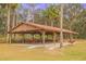 Large open-air picnic pavilion with multiple picnic tables and a grill in a park at 13026 Ne 6 Pl, Silver Springs, FL 34488