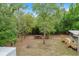 Expansive backyard featuring a deck, storage shed, fire pit, and lush greenery at 8975 Sw 202Nd Avenue Rd, Dunnellon, FL 34431