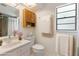 Cozy bathroom with marble countertop, wooden cabinet, and a window with natural light at 8975 Sw 202Nd Avenue Rd, Dunnellon, FL 34431