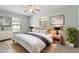 This bedroom features a ceiling fan, large windows and light-colored walls and décor at 8975 Sw 202Nd Avenue Rd, Dunnellon, FL 34431