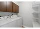 A quaint laundry room with overhead storage and a pair of well-maintained washing and drying machines at 8975 Sw 202Nd Avenue Rd, Dunnellon, FL 34431