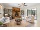 Living room with a stone fireplace, white sofas, and built-in bookshelves at 8975 Sw 202Nd Avenue Rd, Dunnellon, FL 34431