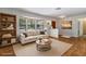Bright living room featuring a sofa, a bookcase, and a large bay window at 8975 Sw 202Nd Avenue Rd, Dunnellon, FL 34431