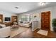 Bright living room with white sofa near bay window and wooden front door at 8975 Sw 202Nd Avenue Rd, Dunnellon, FL 34431
